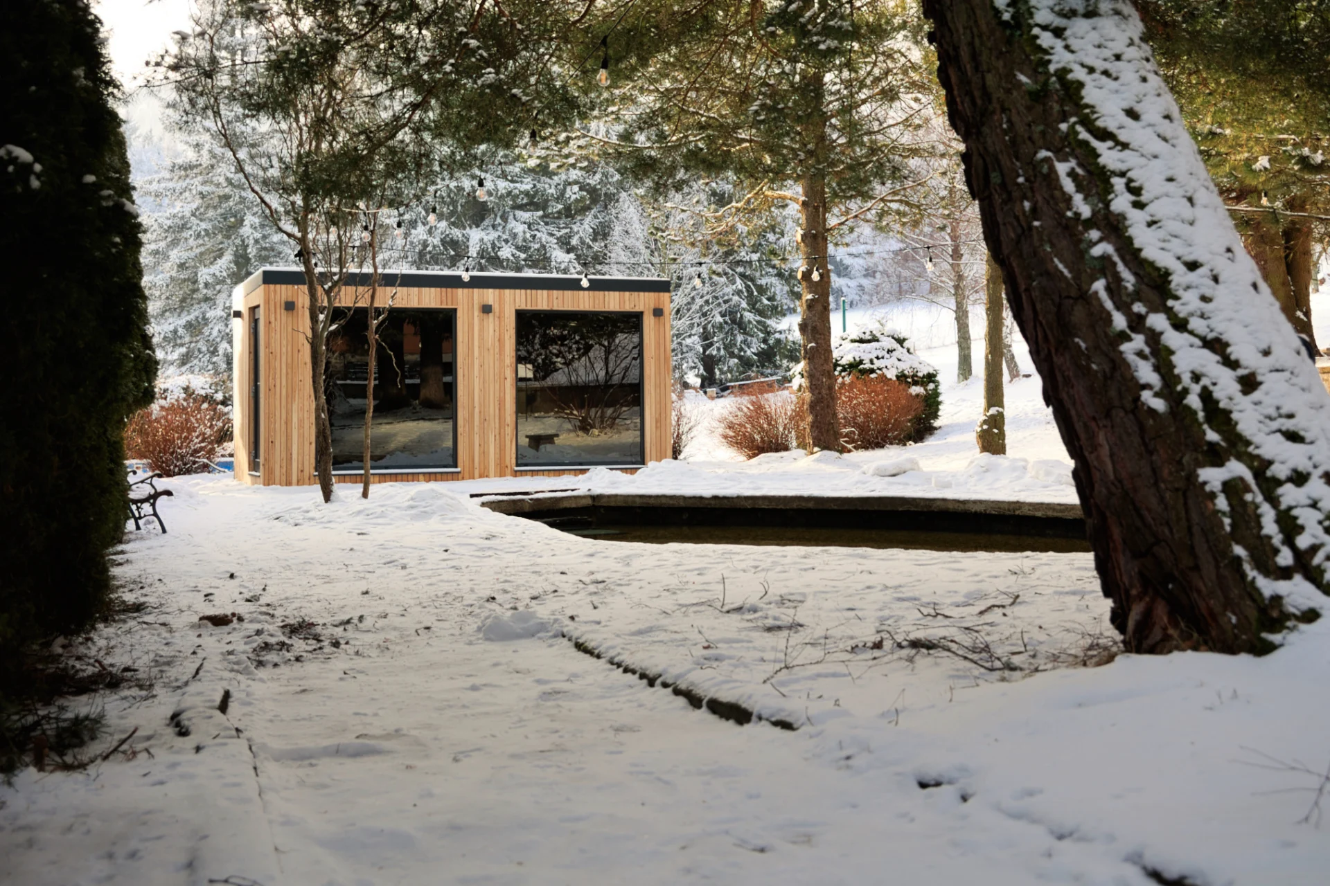 Sauna CUBE s dvoma veľkými oknami v zasneženej záhrade vo Filipoviciach